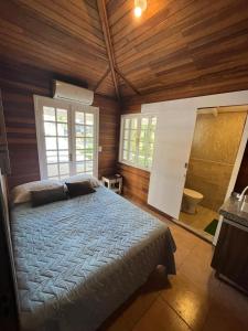 伊达贾伊Vale Beach Pousada的卧室配有一张床铺,位于带木墙的房间内