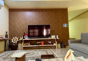 FuvahmulahEndhaa, Divers Home的客厅设有壁挂式平面电视。