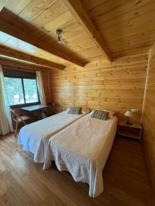 Alfara de CarlesHostal de Montaña Pous de la neu的小木屋内一间卧室,配有两张床