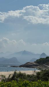 尼泰罗伊Camboinhas Hills的海滩,以海洋和山脉为背景