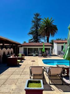 埃斯特角城协和酒店的一个带游泳池、椅子和棕榈树的度假村