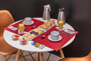 福塔莱萨阿萨依汽车旅馆（仅限成人）的一张带早餐食品和饮料的白色桌子