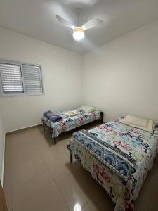圣卡洛斯Apto Apólo - 3 dorm Wifi的客房设有两张床和吊扇。