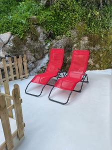 辛特拉Bloom Cottage I - Sintra montain的两把红色椅子坐在围栏旁边的雪地里