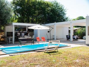 特尔马斯德里奥翁多GOa Hospedajes的一个带遮阳伞和桌椅的游泳池
