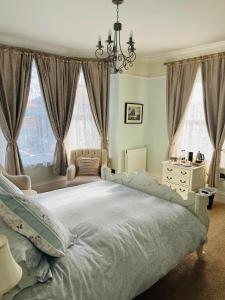 惠特比惠特比阿博特斯雷旅馆的一间卧室配有一张带吊灯的大床