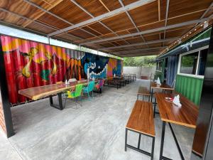 Tierra BlancaOHANA HOTEL & VILLA的餐厅设有桌子,墙上挂着色彩缤纷的壁画