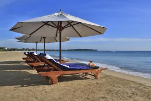 帕西库达Passi Villa的海滩上一排带遮阳伞的躺椅