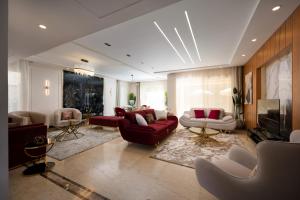 开罗Zyra Luxury villa with pool and Jacuzzi in New Cairo的客厅配有红色沙发和电视