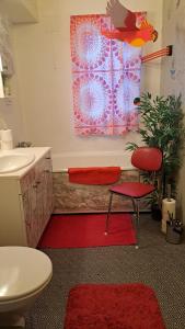 斯沃尔韦尔Kule gule huset的浴室设有红色椅子、水槽和红色地毯。