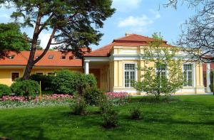 皮耶什佳尼Ensana Vila Trajan的黄色的房子,前面有一个花园