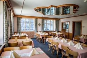 克恩斯Hotel Alpenhof的用餐室设有桌椅和窗户。