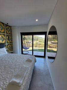 维埃拉·多米尼奥Quinta do Bento的一间卧室配有床和圆镜子