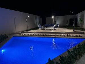 Al Mutaynīyātشاليهــات داكــن的夜晚后院的蓝色游泳池