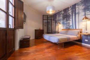 卡利亚里Suite Cagliari -101-的一间卧室配有一张床,铺有木地板
