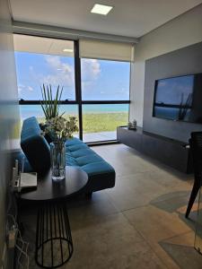 累西腓Flat #2506 BARRA HOME STAY的客厅配有蓝色的沙发和桌子