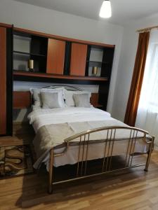 锡纳亚Casa Din Padure的一间卧室配有一张大床和木制床头板