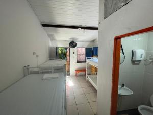 伊塔卡雷Ooxe Hostel的一间带水槽的浴室和一间房间