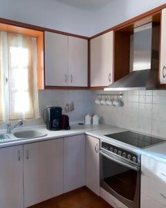 斯基罗斯岛Nereid Skyros House的厨房配有白色橱柜、水槽和炉灶。