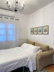 斯基罗斯岛Nereid Skyros House的一间卧室配有一张带白色床单和吊灯的床。
