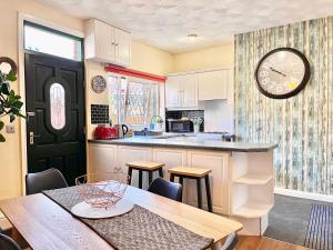 巴恩斯利Summer Lane House-3 Bedrooms-Close to M1-Longer Stay-Free Parking的厨房配有桌子和墙上的时钟