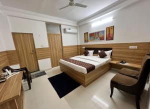 Sītāpur MūāfiHotel Parvati Residency的一间卧室配有一张床、一张桌子和一把椅子