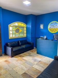 维多利亚Onça da Praia Hostel的蓝色的客房配有黑色皮沙发和台面