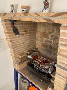 OrbaCasa Doble Sueno的砖炉,上面有食物烹饪