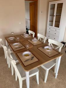 OrbaCasa Doble Sueno的一张带白色椅子的木桌和一间餐厅