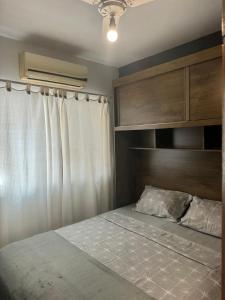 阿拉亚尔-杜卡布Serra Mar Suítes,Lofts, e casas à 300 metros das praias的一间卧室配有一张带木制床头板的床