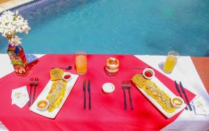 NindiríHotel Amigo Nicaragua的一张桌子,上面有食物和饮料,放在红色桌布上
