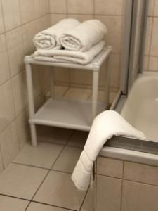 梅拉内Hotel zur Eiche的浴室提供毛巾,位于浴缸旁的毛巾架上