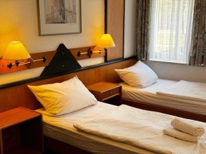 梅拉内Hotel zur Eiche的配有两盏灯的小房间内的两张床