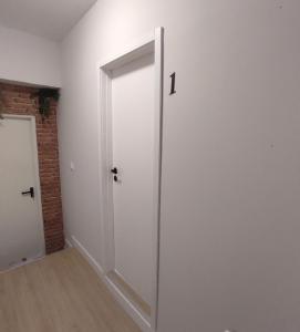 MoreiraAerostay Hostel的砖墙房间的白色门