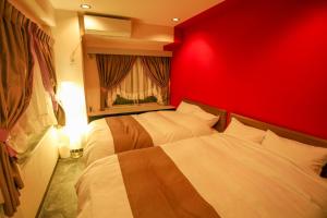 名古屋Fushimi Yokkusu Building 10F - Vacation STAY 16301的红色卧室设有两张床和红色的墙壁