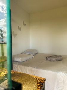 Capão do LeãoChacara Recanto do Pinheiro的墙上有蝴蝶的房间的两张床