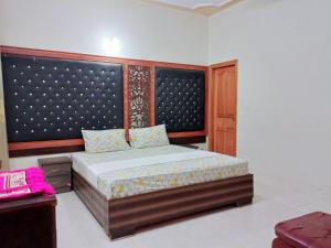 卡拉奇Rose Palace Guest House的一间卧室配有一张带大床头板的床