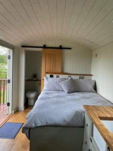 波士顿Woodpecker Shepherds Hut的房屋内一间卧室,配有一张大床