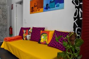塞维利亚Sevilla Urban Flat的客房内的黄色沙发,配有色彩缤纷的枕头