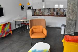 塞维利亚Sevilla Urban Flat的厨房配有橙色椅子和桌子