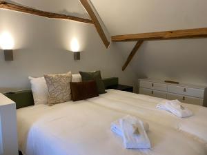 OpglabbeekHotel De Hoogmolen的卧室配有带毛巾的大型白色床