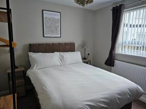 斯凯格内斯The Ivernia hotel的一间卧室配有一张带白色床单的床和一扇窗户。