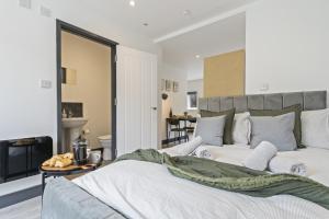 伊肯斯顿The Olive Suite的卧室配有一张白色大床和壁炉