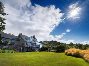 皇后镇Hidden Lodge Queenstown的天空阳光下的草坪上的房子