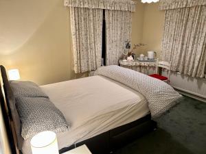 FeockCurlews的一间卧室配有床和带窗帘的窗户