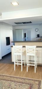 林茨3-Zimmer- Wohnung in Traun, nähe Linz und Wels的厨房配有2把白色椅子和桌子