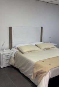 拉卡莱拉Glamping termales La Calera的一间卧室配有一张大床和一个床头柜