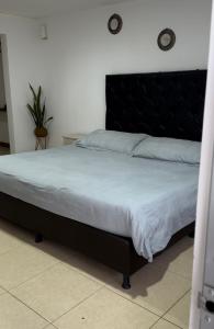 拉卡莱拉Glamping termales La Calera的卧室内一张带黑色床头板的床
