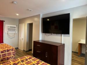 埃尔卡洪El Cajon Inn & Suites的酒店客房设有两张床和一台平面电视。