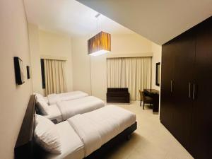 迪拜AlRaef Luxury Apartments的酒店客房设有两张床和吊灯。